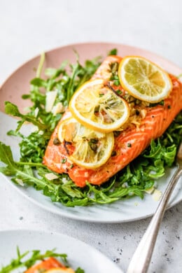 Baked Steelhead Trout with lemon and arugula on a plate