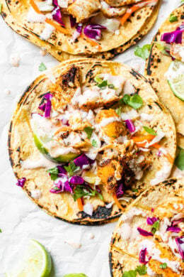 This easy, healthy fish taco recipe is made with cod seasoned with a chili-lime cumin rub topped with slaw – no breading, no frying!