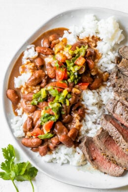 Dominican Beans over rice with aji picante on top and steak on the side.